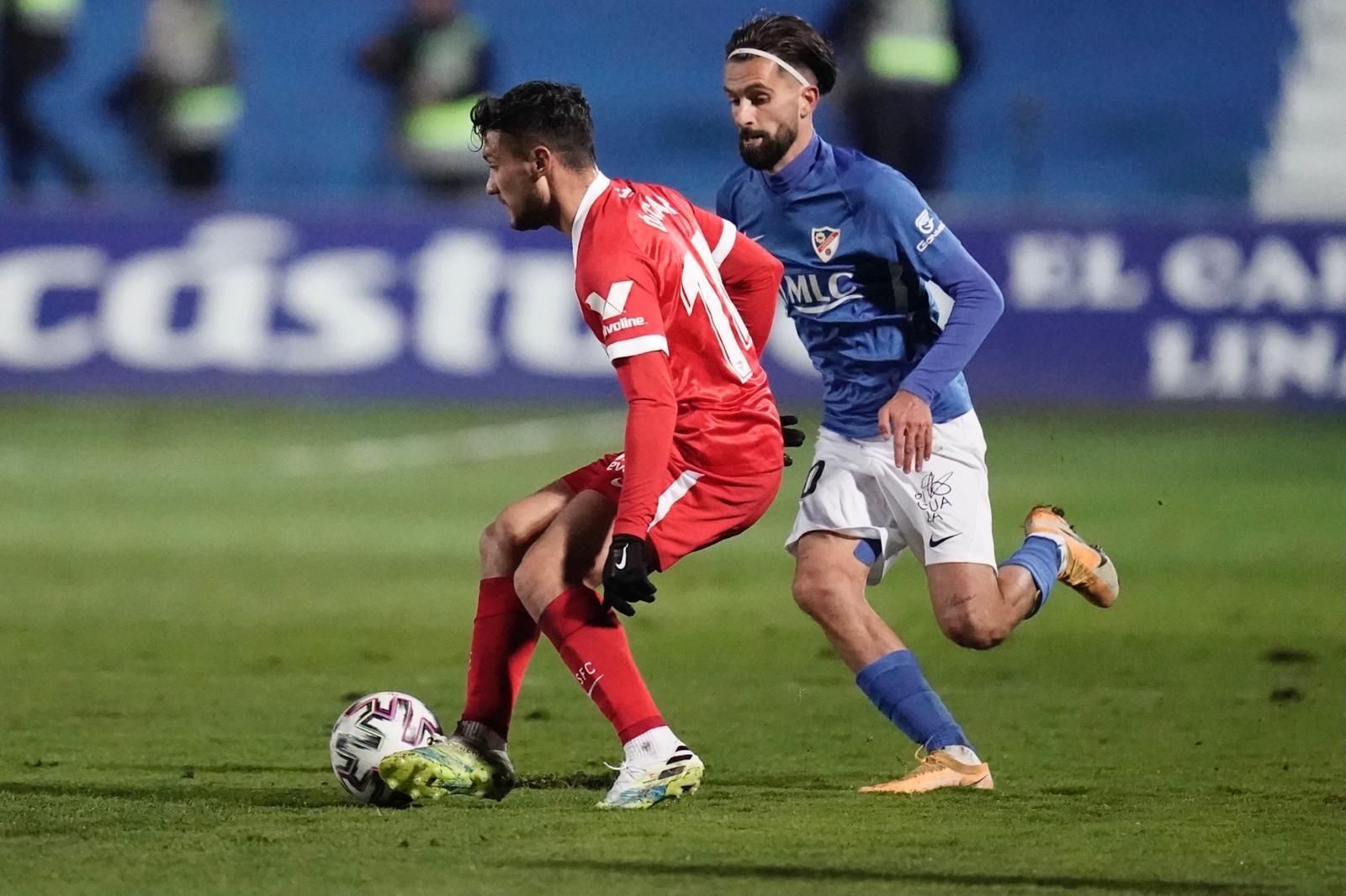 Óscar Rodríguez, el goleador sevillista, golpea el balón ante Carnicer.
