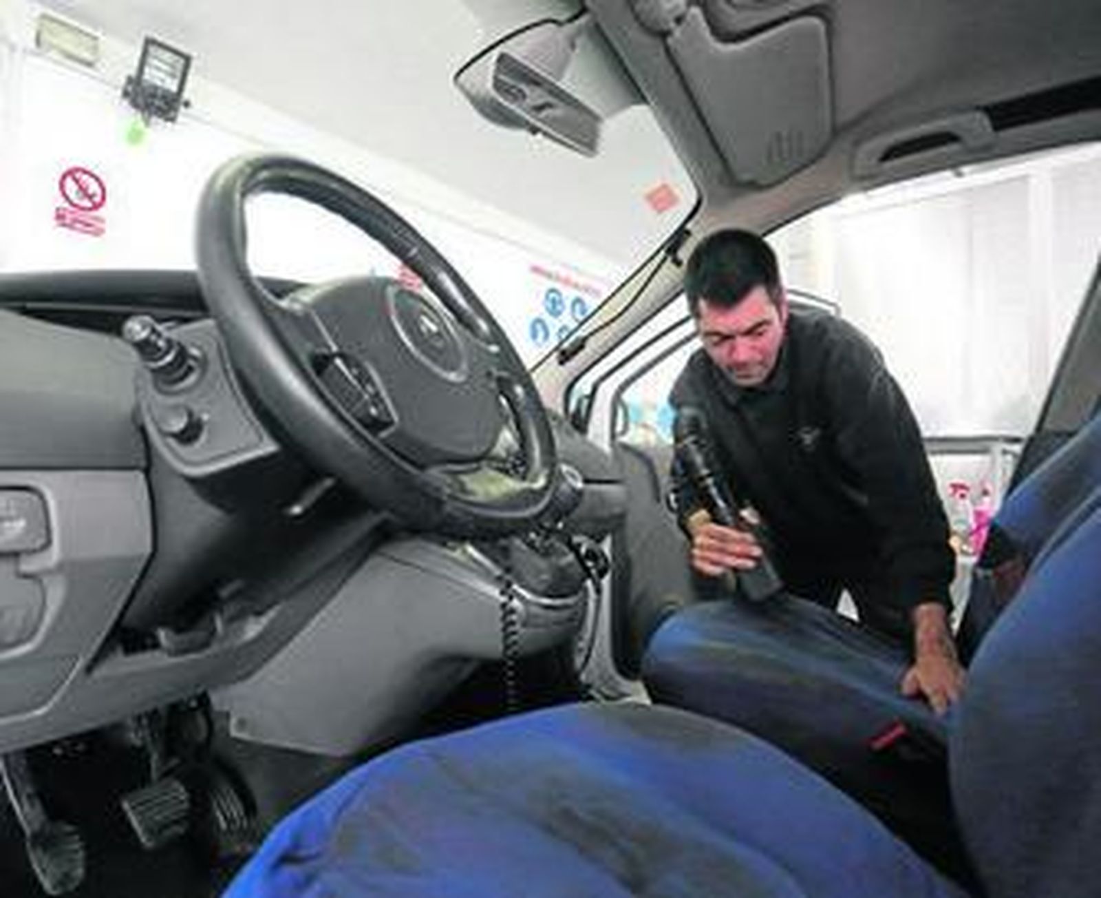 Un trabajador de Aspromanis Servicios limpia un coche, en las instalaciones de la calle Ferreteros.