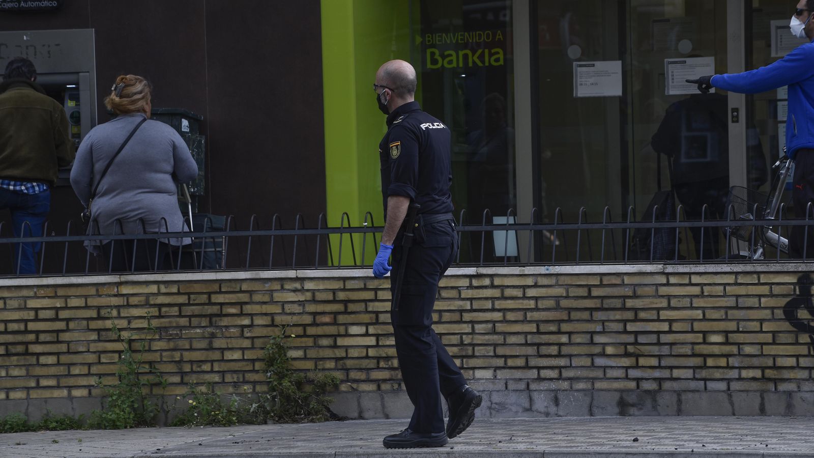Un agente de la Policía Nacional inspecciona los alrededores de un banco