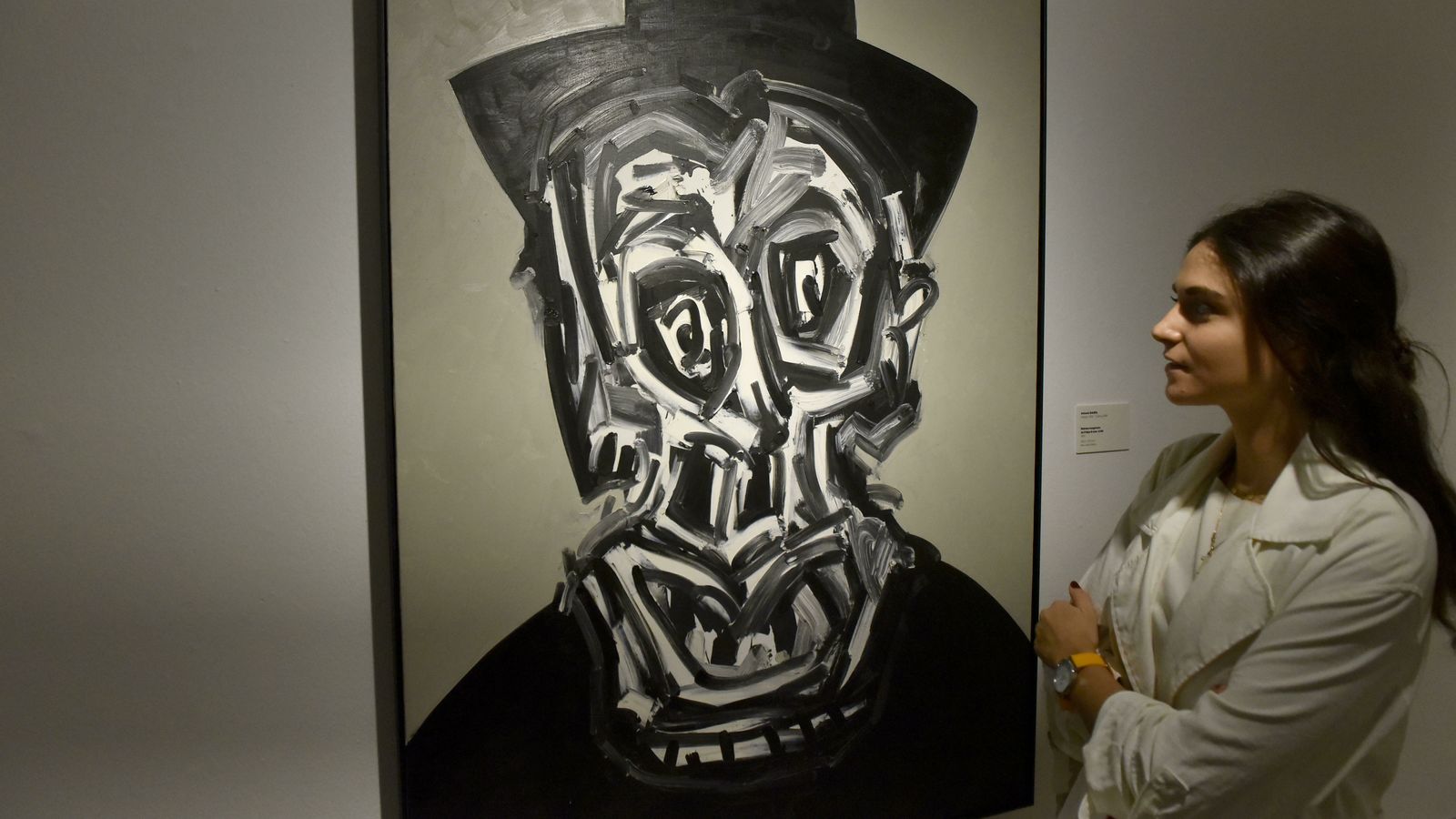 Una joven contempla el 'Retrato imaginario de Felipe II' de Antonio Saura.