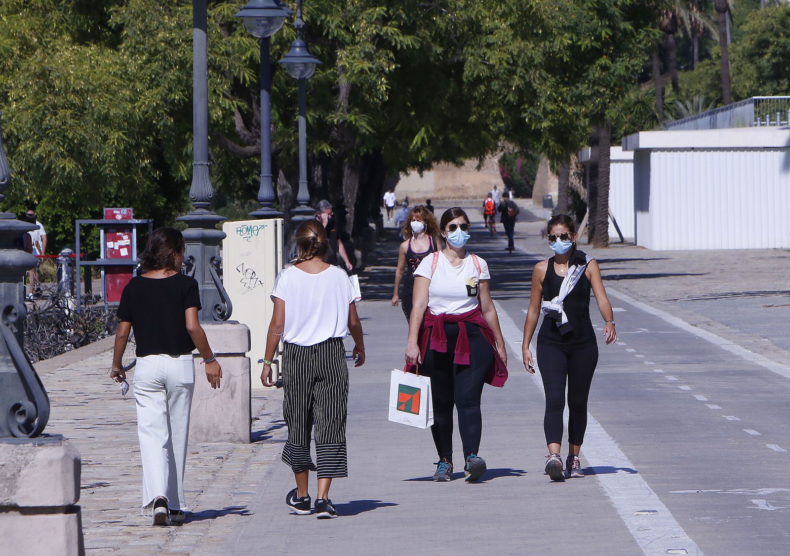 Varias personas caminan por una calle peatonal en la ciudad de Sevilla.