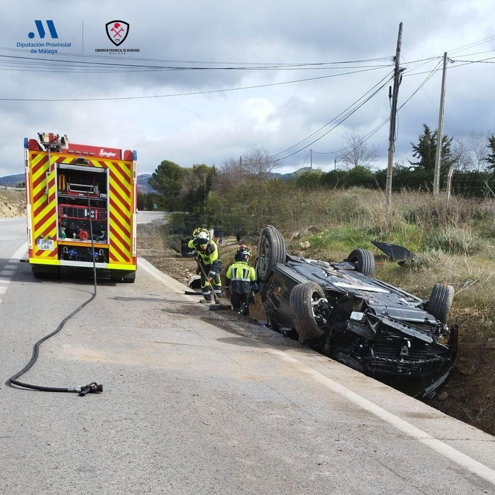 Bomberos del Consorcio Provincial de Málaga, junto al vehículo accidentado en la A-367.