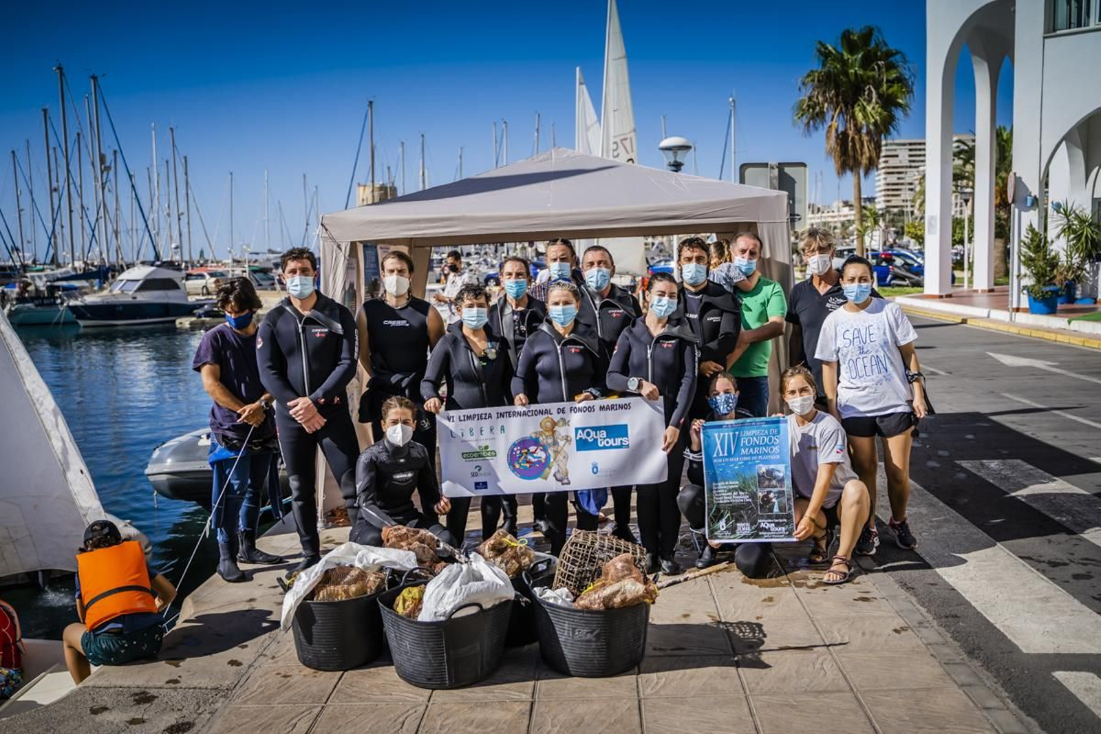 Participantes en la limpieza de fondos marinos, con parte de la basura extraída del mar.
