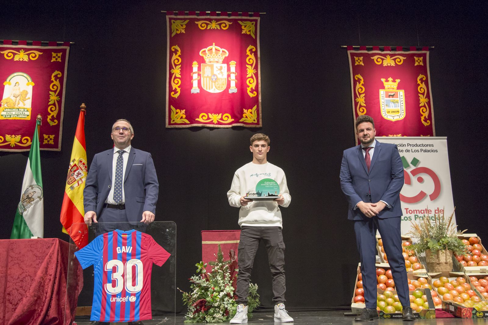 Gavi recoge el premio junto al alcalde de Los Palacios y Villafranca, el delegado de Deportes y los kilos de tomates.