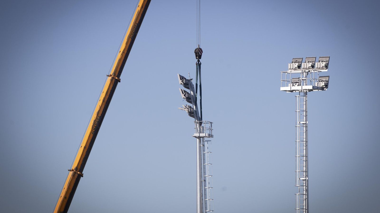 Una de las grúas instalando la torre de iluminación
