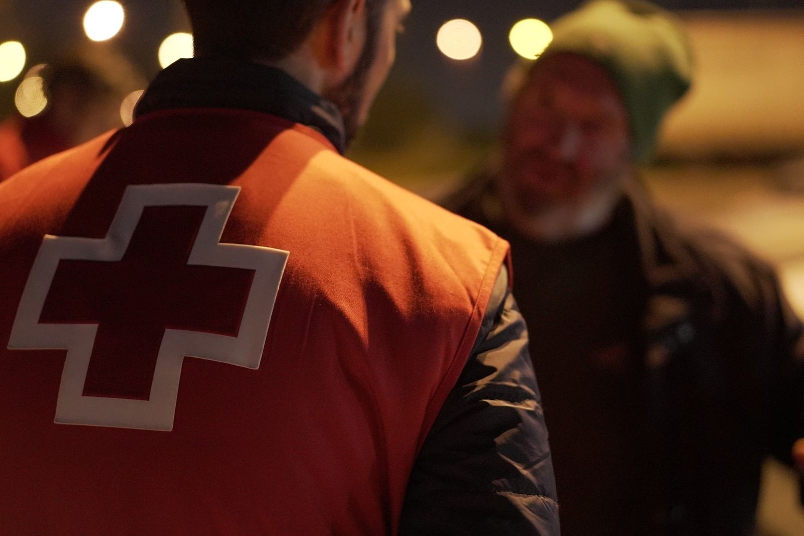 Un voluntario de Cruz Roja atiende a una persona sin hogar