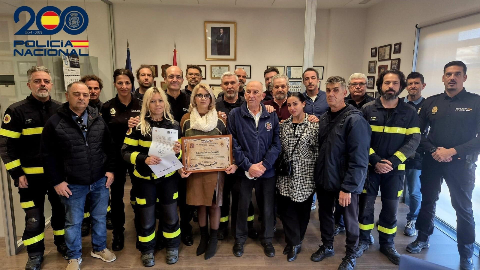 En el centro de la imagen, la viuda del bombero fallecido Carlos Altar durante el homenaje en la comisaría de Policía Nacional