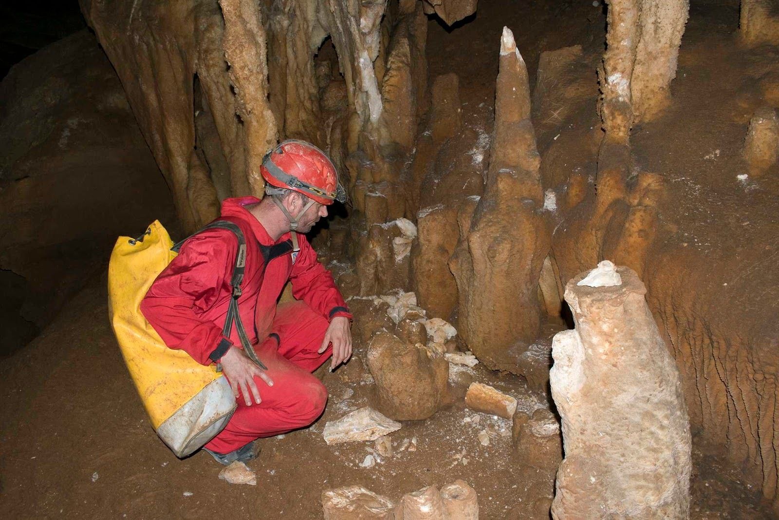Un espelólogo muestra las roturas producidas en las formaciones.