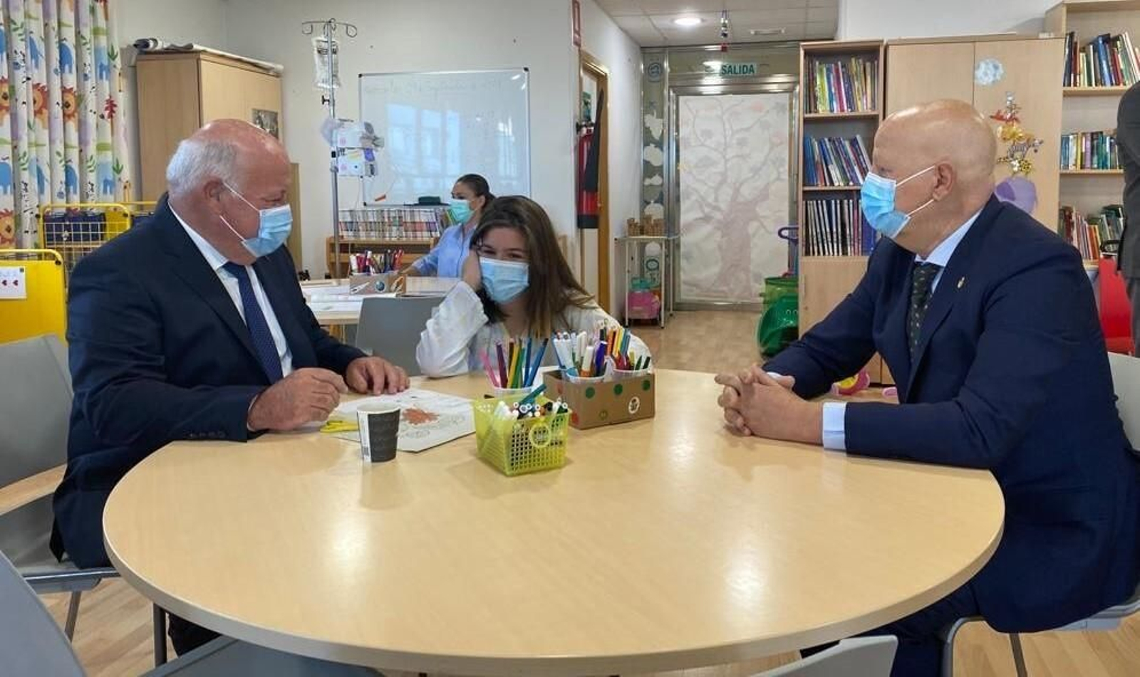 Aguirre e Imbroda hablan con una niña en el aula hospitalaria del Reina Sofía.