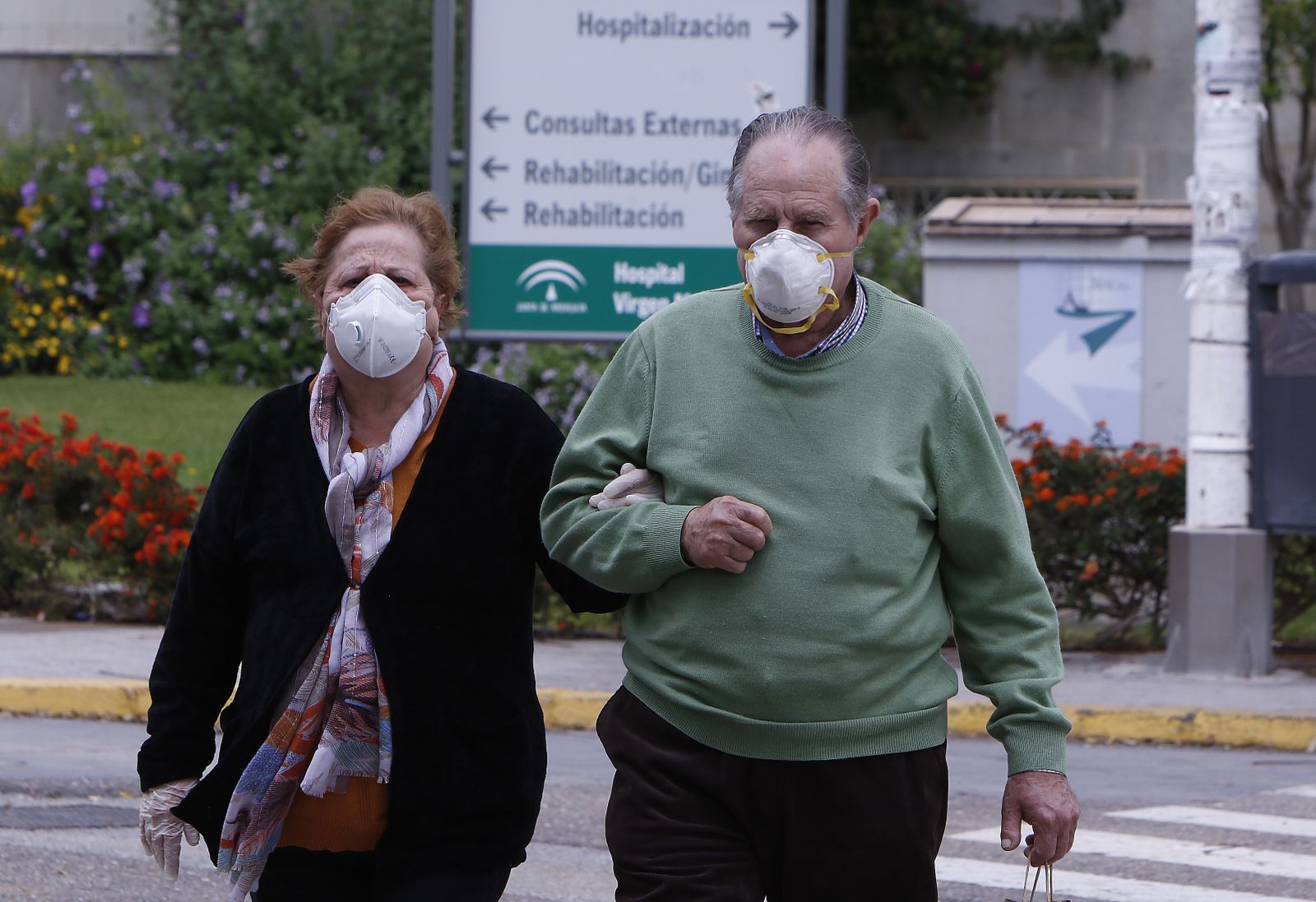 Una pareja camina agarrada del brazo en los aledaños del Hospital Virgen Macarena.