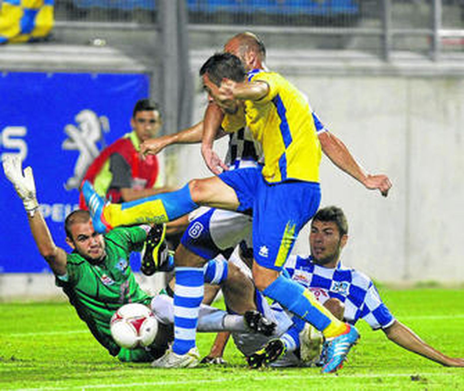 Adrián Gallardo intenta rematar ante la oposición del portero del Arroyo y de dos defensas.