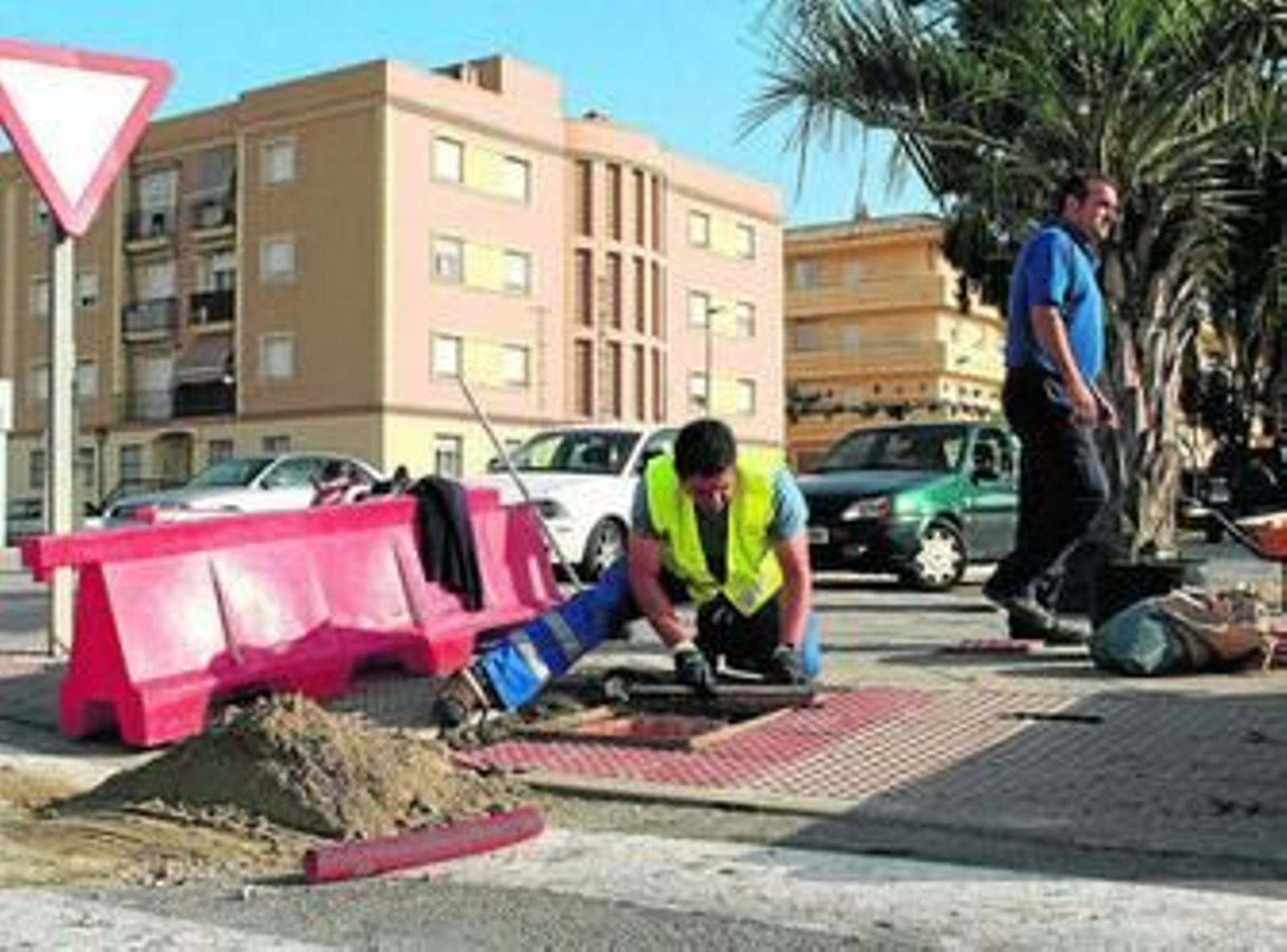 Dos trabajadores municipales trabajan en la mejora de un tramo de acerado en Tercer Centenario.