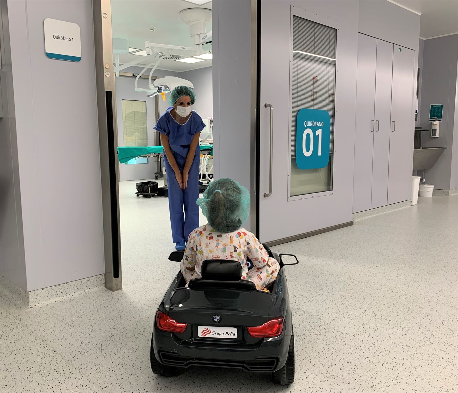 La doctora Jiménez con una paciente que conduce un cochecito hasta la entrada a quirófano.