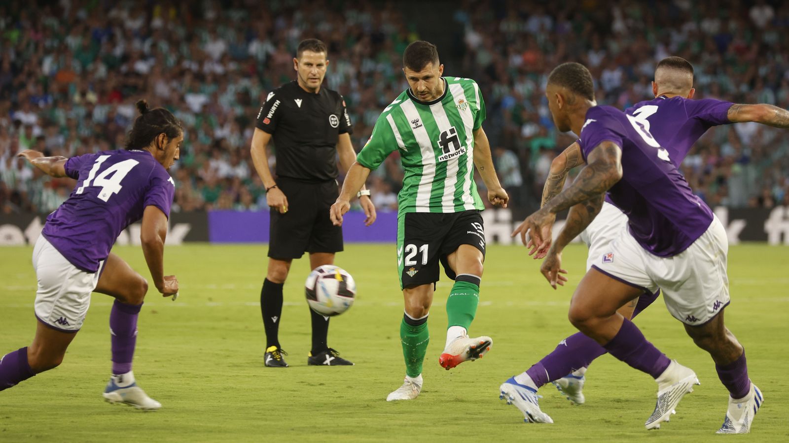 Guido Rodríguez da un pase entre tres futbolistas de la Fiorentina.