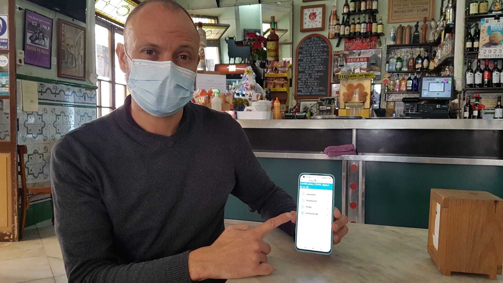 Vicente Sordo Fernández, propietario del Bar Los Pepes, mostrando la aplicación para autentificar el certificado Covid.
