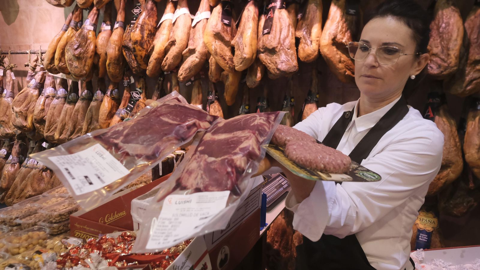 Dependiente de Ultramarinos Andalusí muestra varias de las carnes más vendidas para estas navidades.