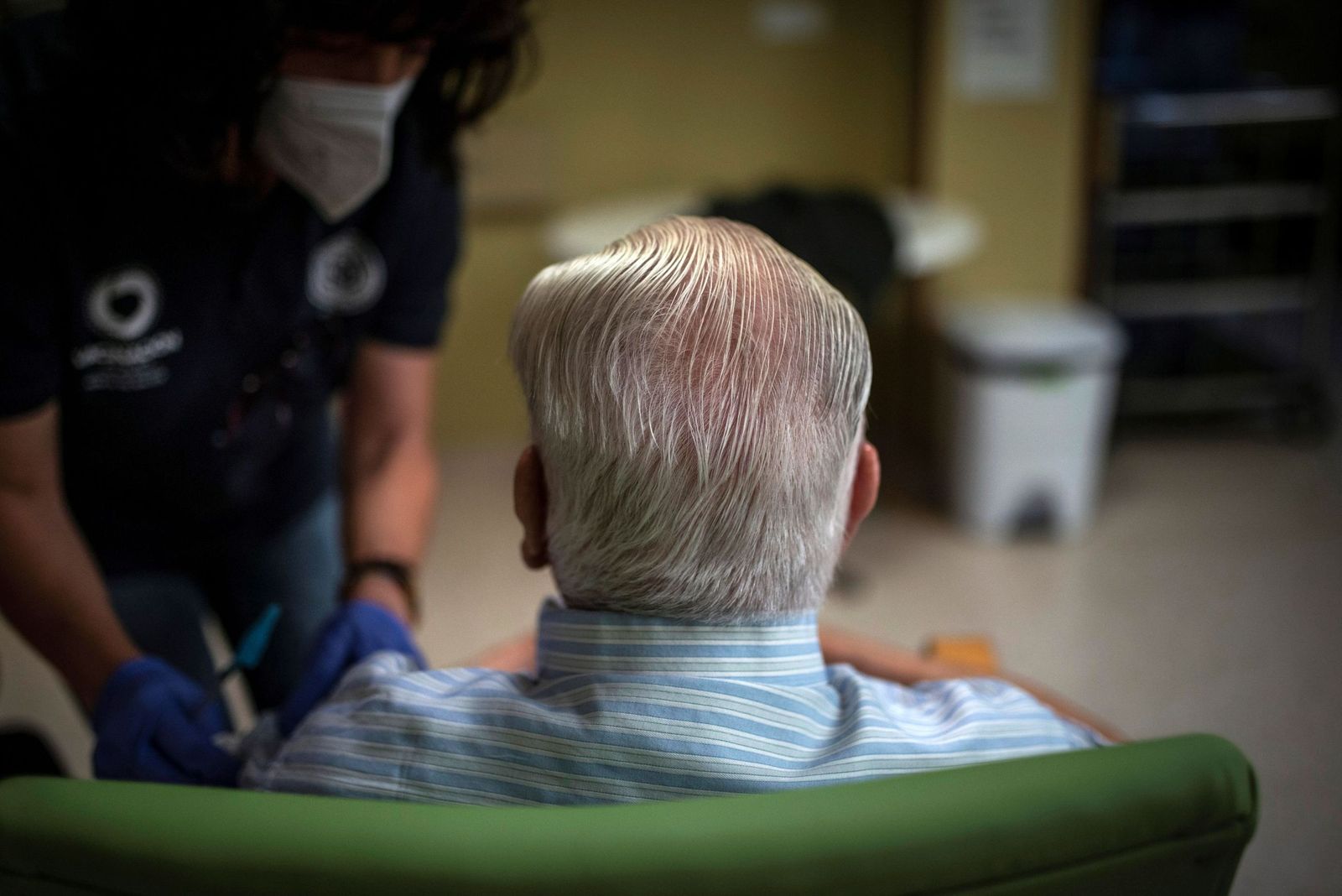 Una sanitaria atiende a un hombre en una residencia de Málaga.
