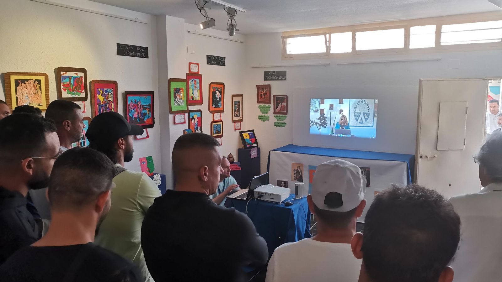 Los internos contemplan el audiovisual que acompaña a la exposición.