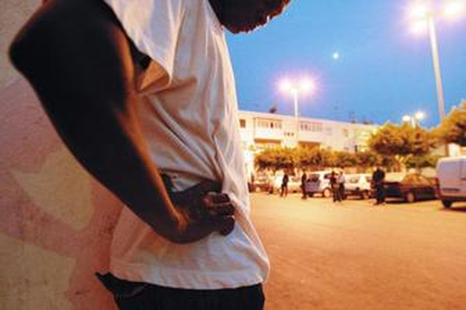 Un vecino de las 200 Viviendas, en primer plano, frente a varios agentes de vigilancia en Roquetas.