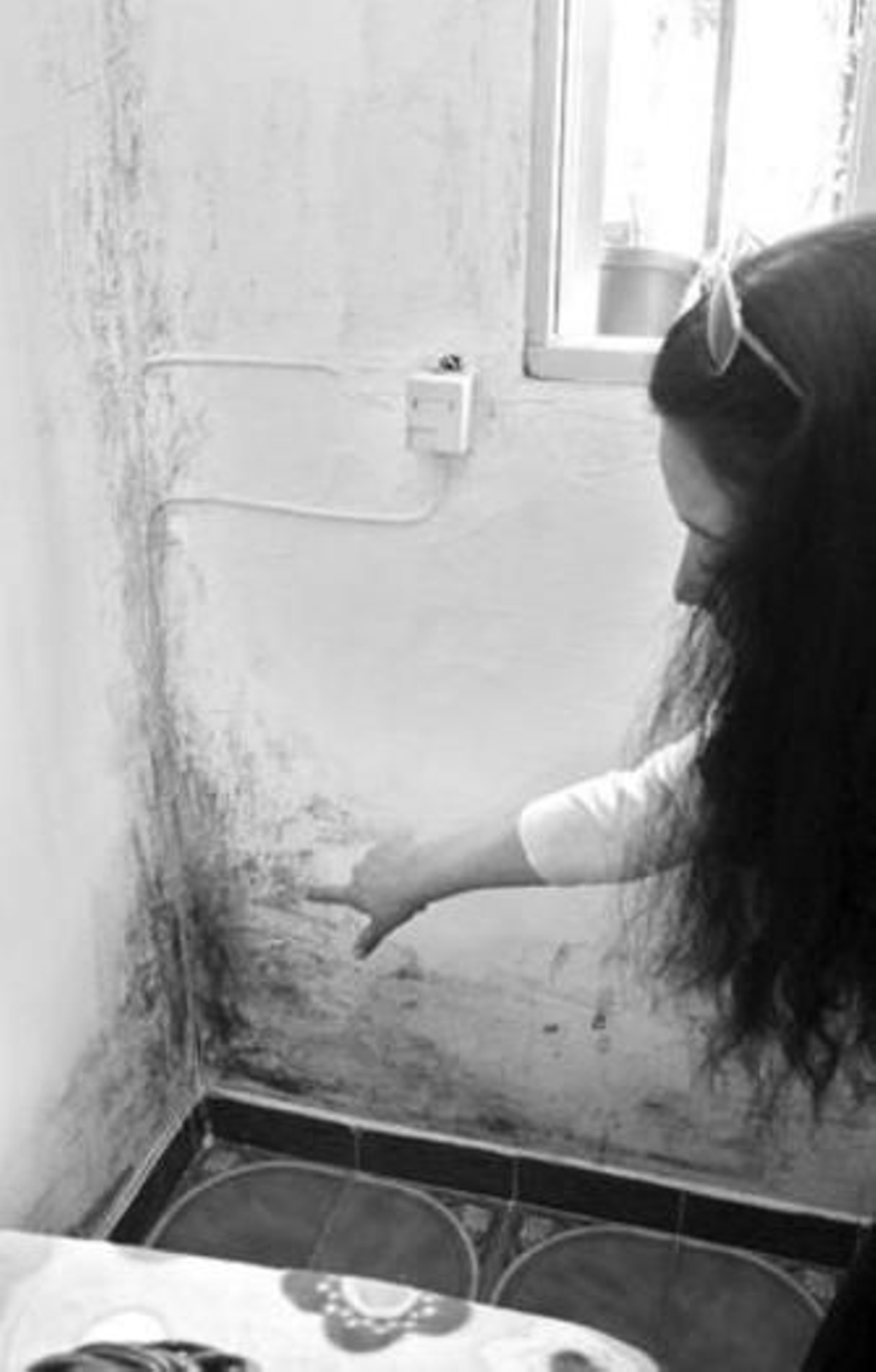 Una afectada muestra las grietas aparecidas en su casa.