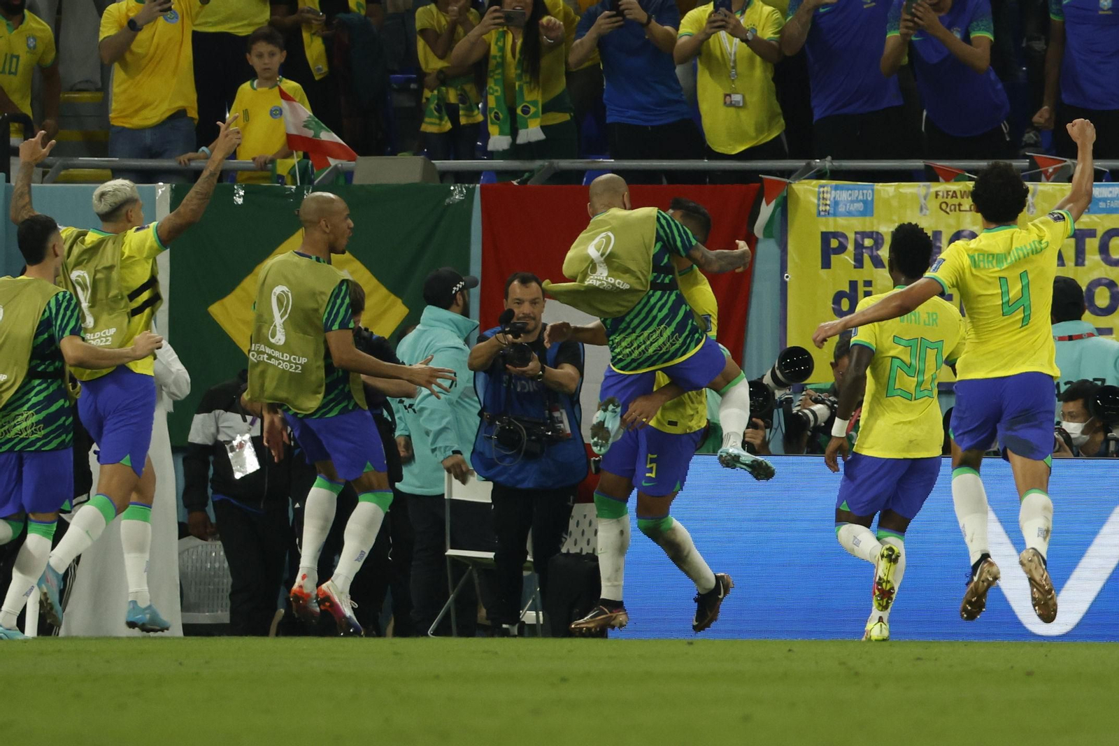 Daniel Alves se abraza eufórico a Casemiro mientras se acercan otros suplentes tras el gol de Brasil.