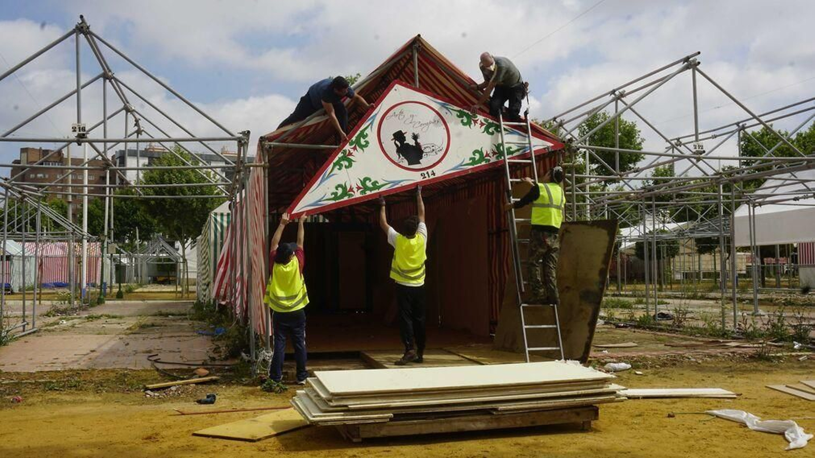 Cinco operarios desmontando ayer la pañoleta de una caseta.