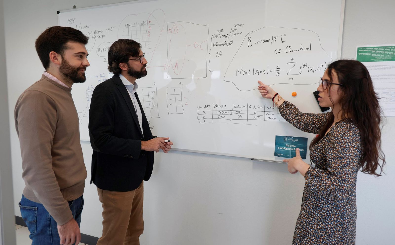 Miguel Ángel Armengol, en el centro, junto a dos de los integrantes de su departamento en el Laboratorio de Ciencia de Datos de la Fundación Progreso y Salud, en pleno análisis de datos.