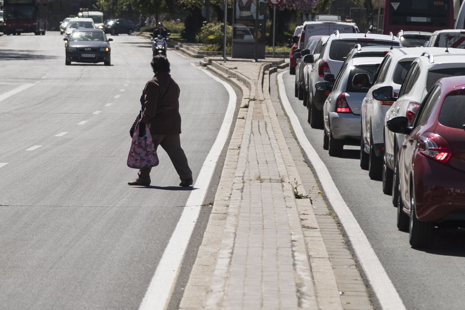 Una mujer cruza de forma imprudente por la avenida San Juan de Ribera, el tramo anterior al Hospital.