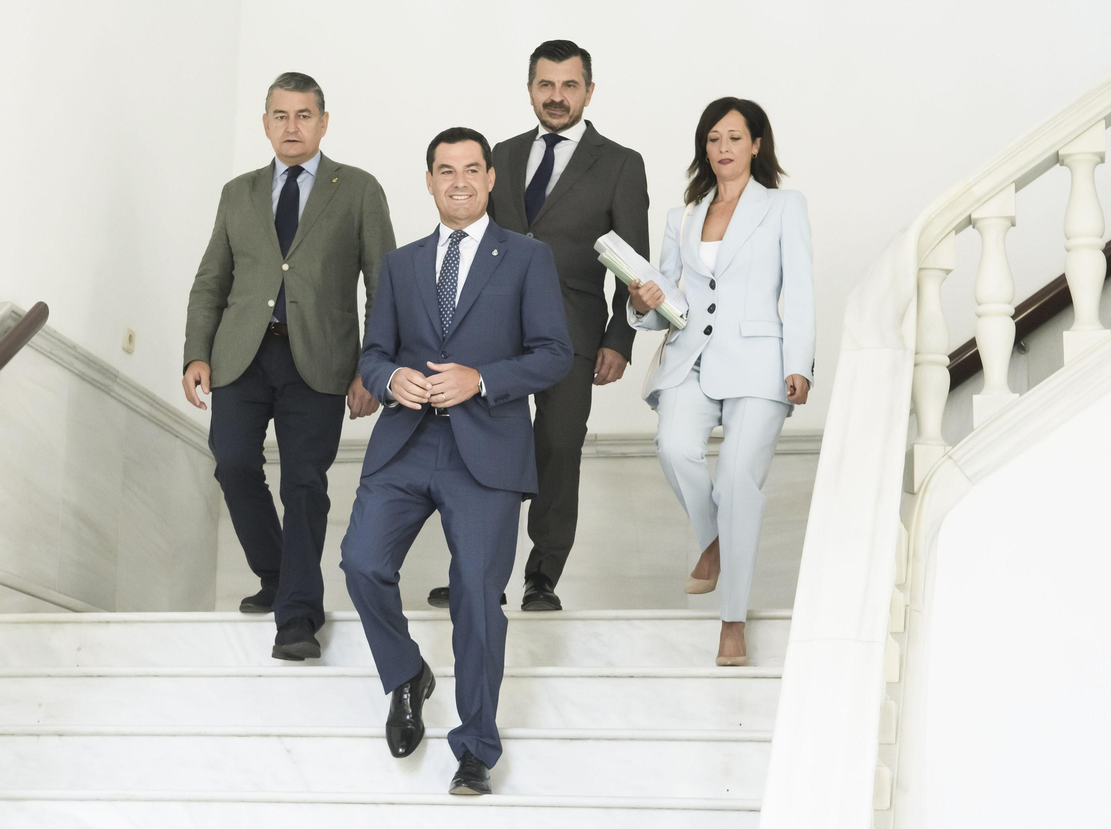 Juanma Moreno baja a la sala de plenos del Parlamento andaluz.