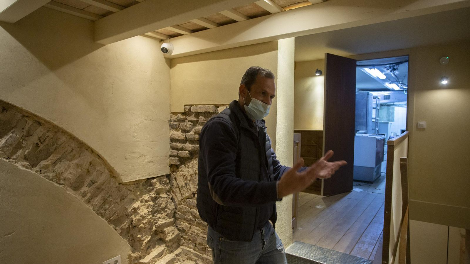 El arqueológo Álvaro Jiménez ante el arranque del  único arco que se conserva de la sala caliente.