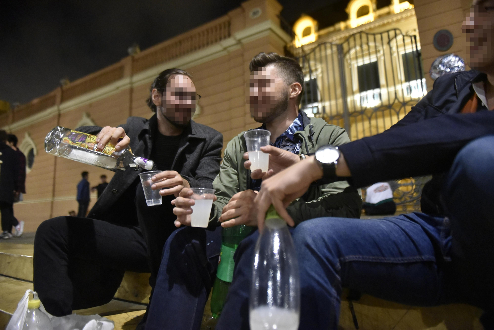 Tres jóvenes beben en la Alameda de Hércules.