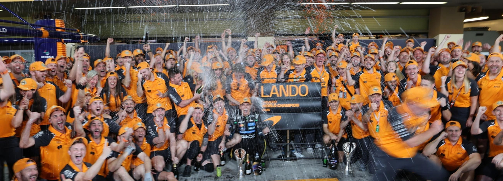 Lando Norris celebra su título mundial con todo su equipo en el boxe de McLaren.