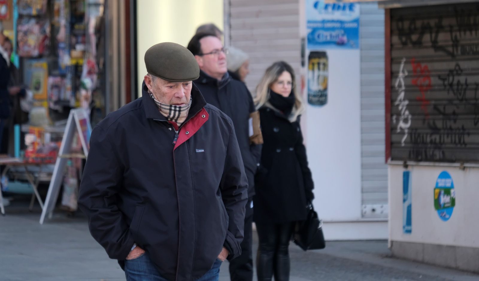 Varias personas caminan por una calle de Córdoba en un día frío.