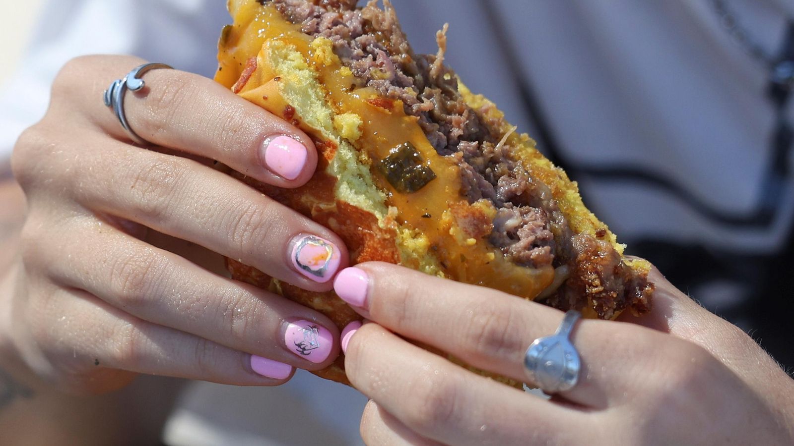 Un chica come una hamburguesa en The Champions Burger.