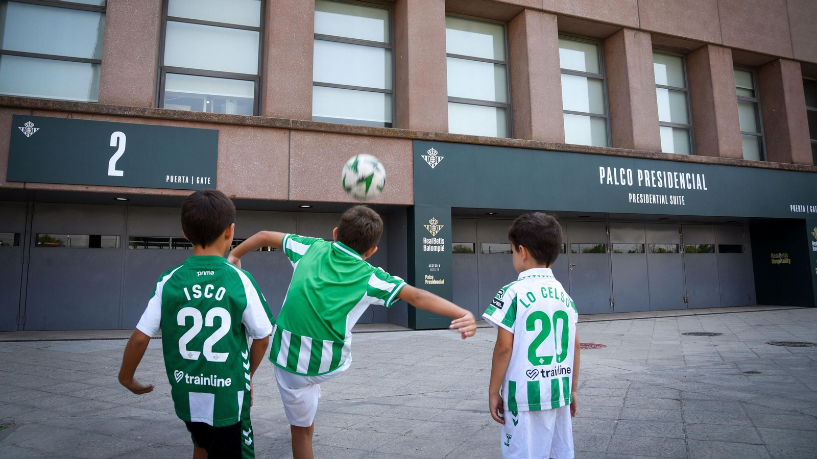 Tres pequeños socios del Betis, todos de Villanueva del Ariscal, ayer jugando a la pelota junto al Estadio de la Cartuja.