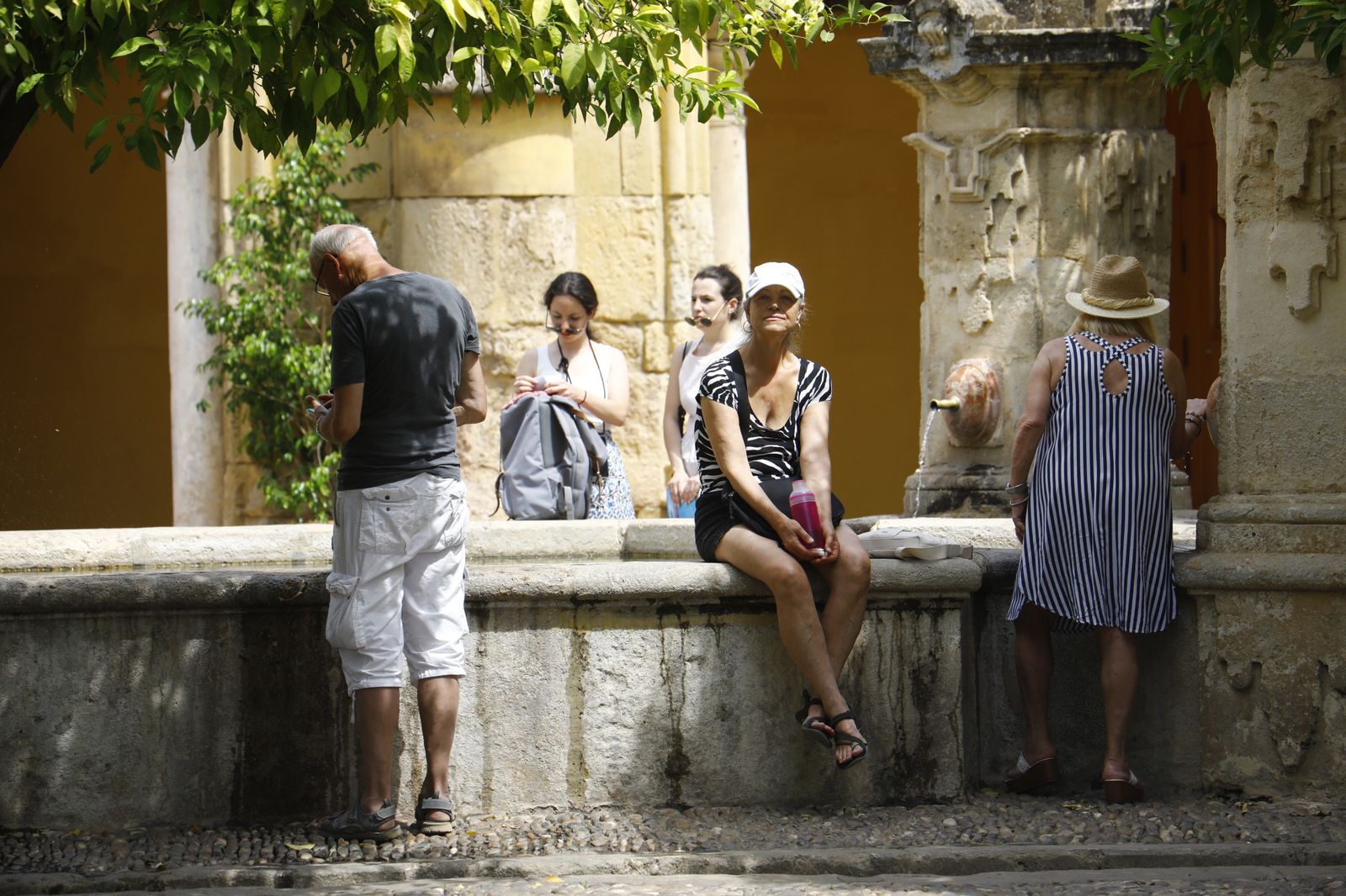 Imágenes de la ola de calor en Córdoba: sombreros, paraguas y fuentes para sobrevivir al aviso naranja