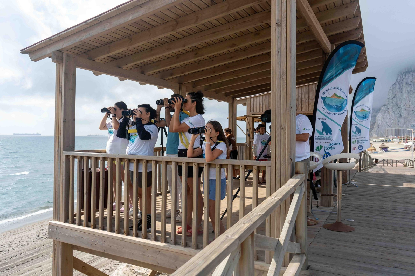 Un grupo de menores en una de las sesiones de observación de ballenas y cetáceos  en la playa de Santa Bárbara en La Línea.