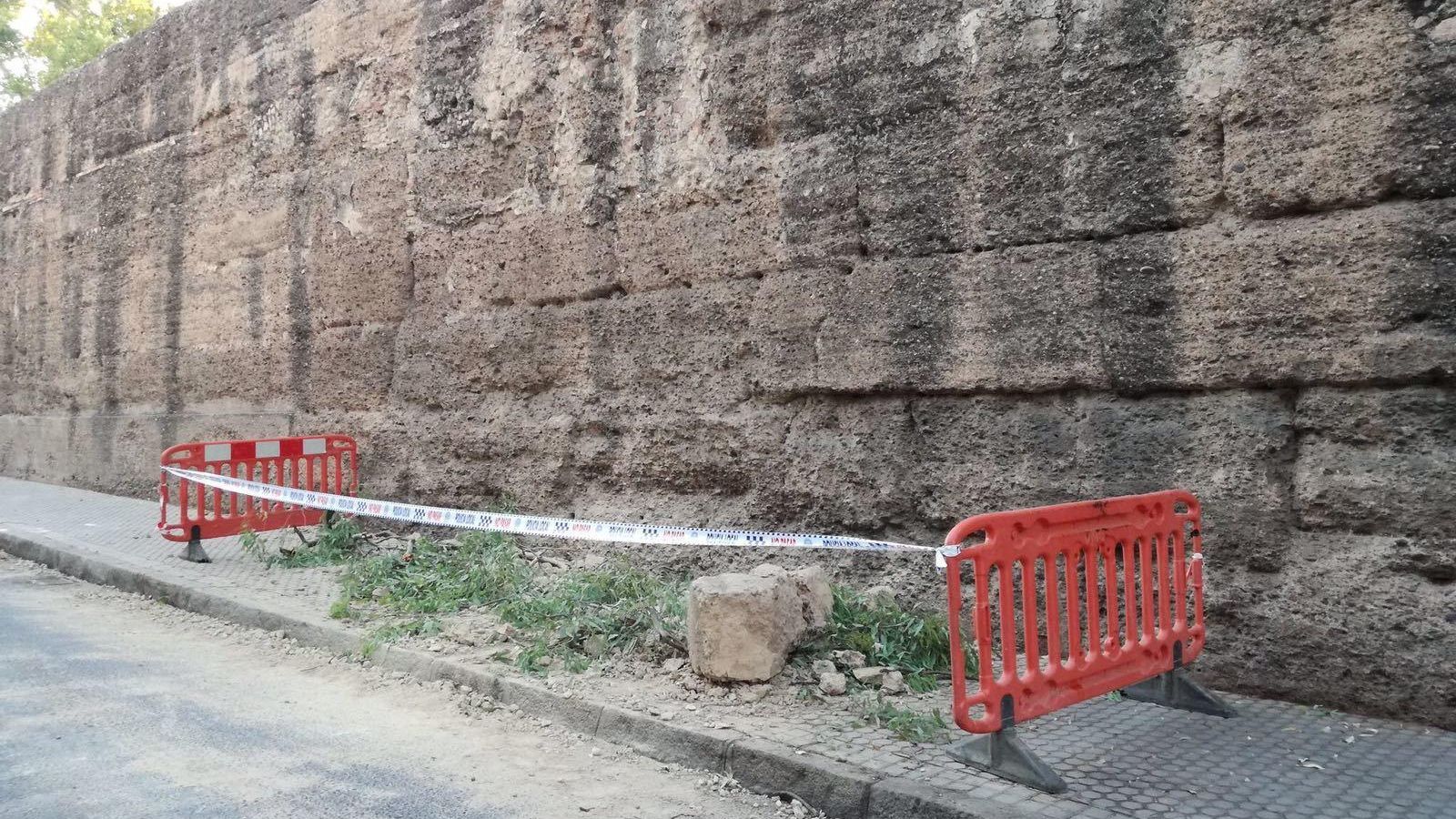 Dos vallas cercan la almena caída desde la muralla de la Macarena.