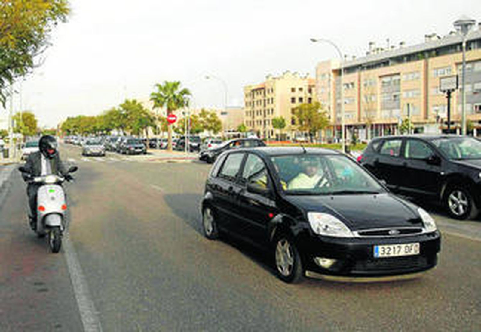 Un vehículo y un ciclomotor circulan por la avenida Isla de Fuerteventura.