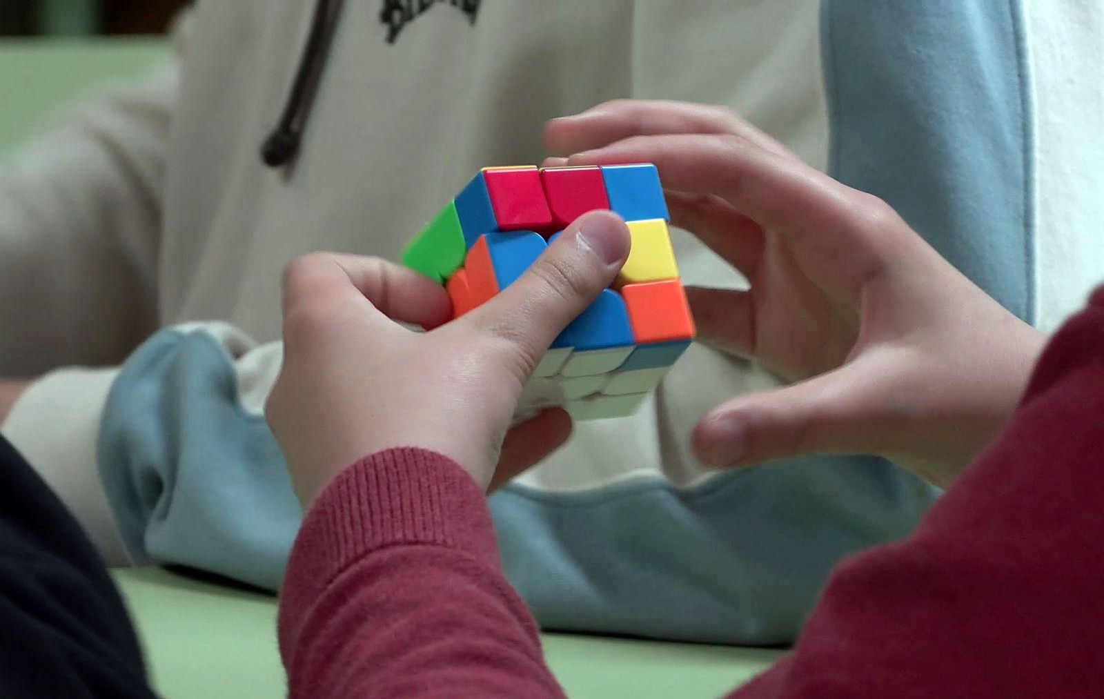 Un niño  maneja un cubo de Rubik.