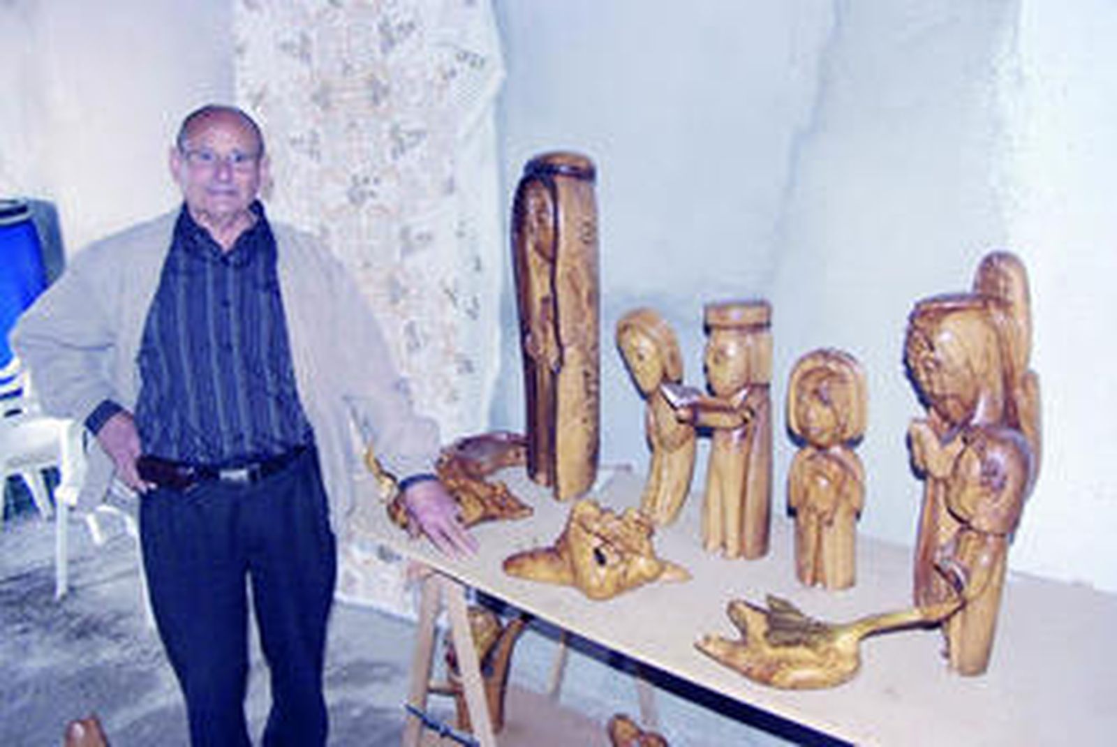 Pedro Gilabert Bonillo, rodeado de sus esculturas en madera de olivo en su casa de Arboleas.