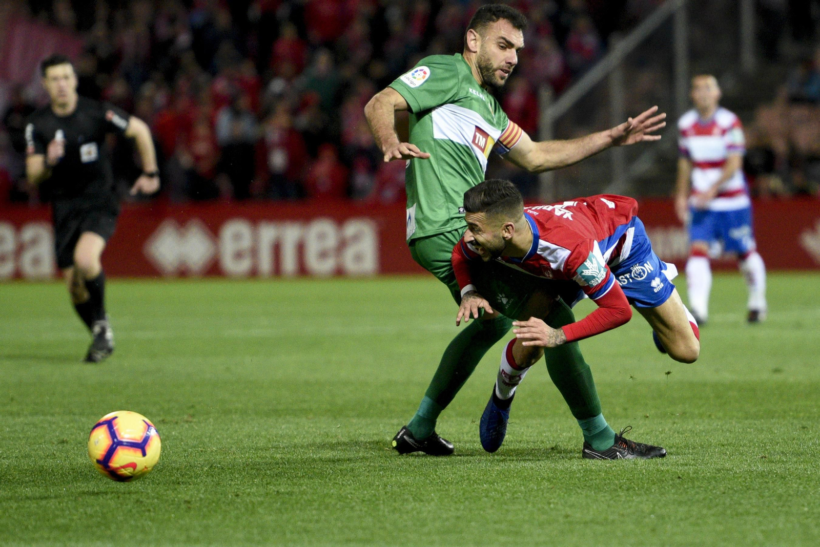 Vadillo aguanta la dura entrada de un rival del Elche, después de haberlo regateado.