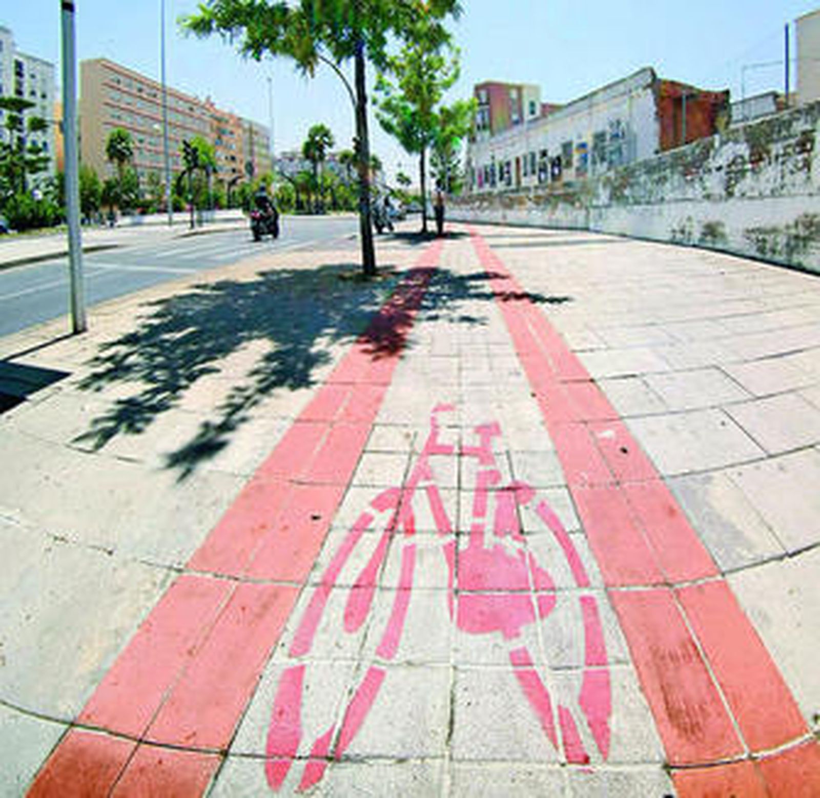 El carril bici de la Juan Carlos I llega un momento que está cortado por un muro que lo invade.