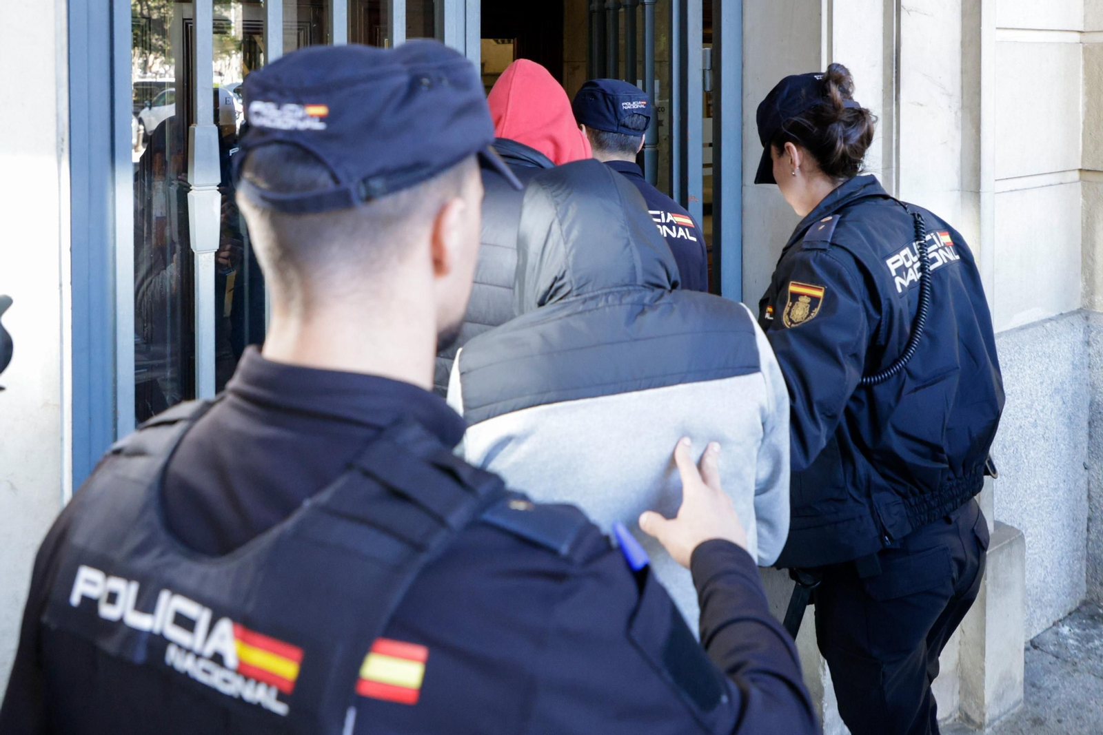 Tres agentes de la Policía Nacional escoltan a varios detenidos, en una imagen de archivo.