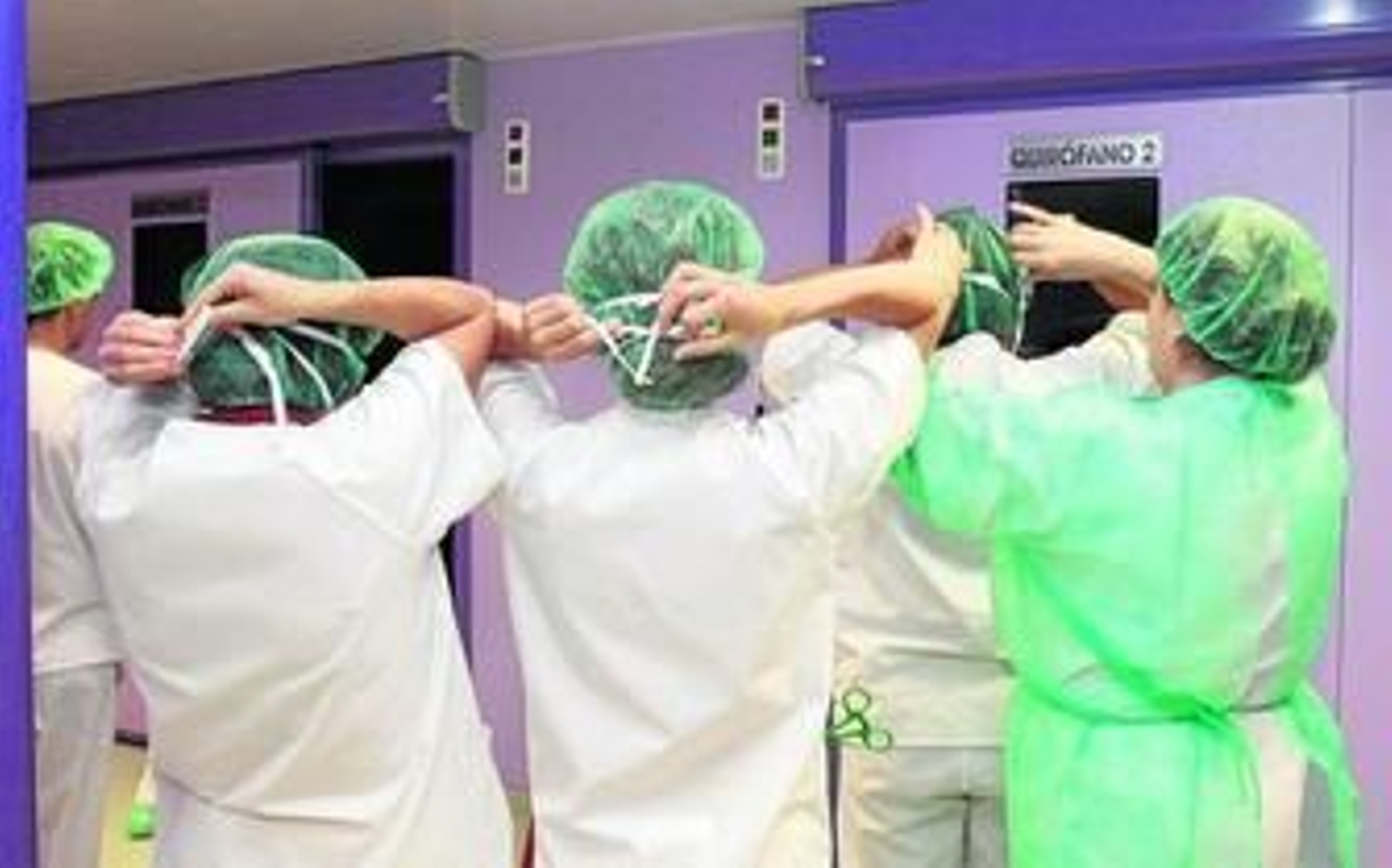 Mujeres profesionales de la medicina se preparan para entrar en un quirófano.