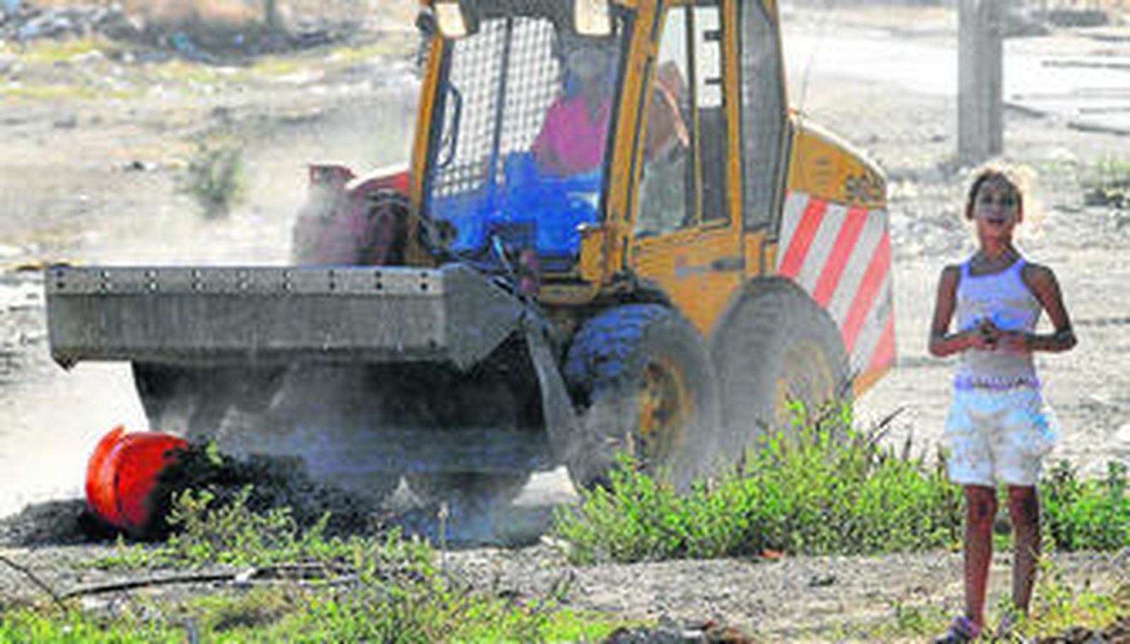 Operación especial en Torreblanca. Sobre estas líneas, una máquina de Lipasam limpia el solar de la calle Castaño. A la izquierda, Zoido se sube a uno de los camiones de la empresa de limpieza y saluda a un operario. Debajo, un perro pasea por la zona ante un grupo de vecinos y el establo casero en el que se hallaba un pony.