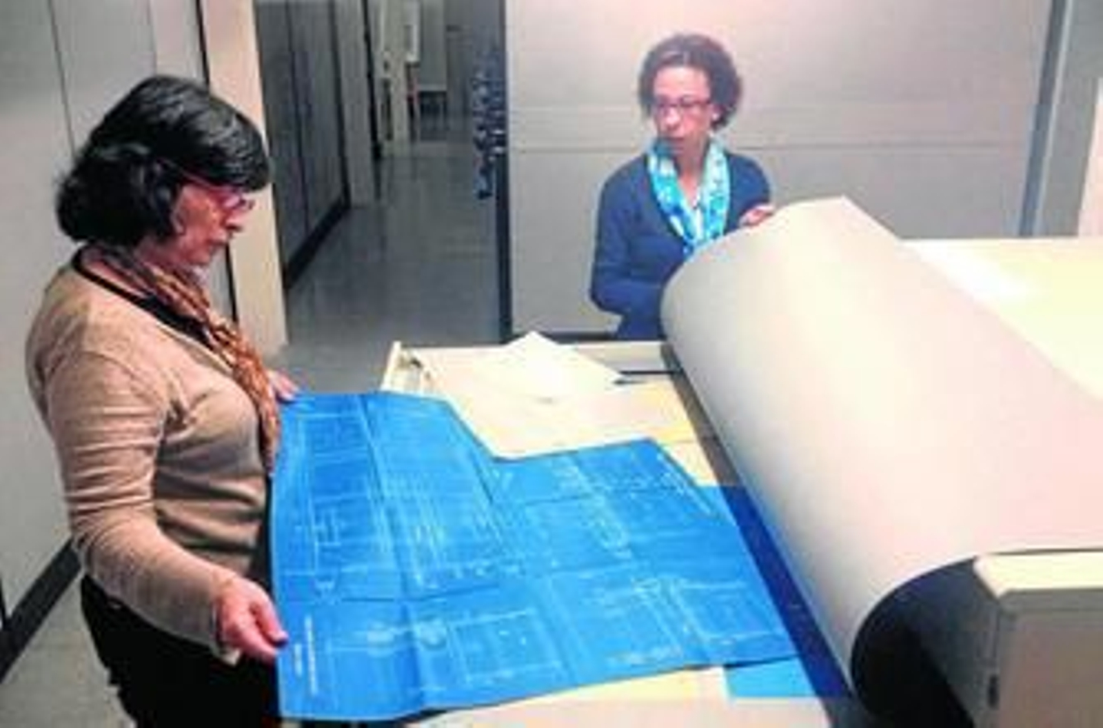 1. La jefa del Archivo de la Autoridad Portuaria de Huelva, Ana María Mojarro, muestra alguno de los planos del depósito. 2. Zona de estudio y consulta para los investigadores y visitantes. 3. El documento más antiguo data del año 1873, fecha en la que se creó la Junta de Obras del Puerto de Huelva. 4. Imagen de algunas de las estanterías del depósito. 5. Varios anuarios de principios del siglo XX.