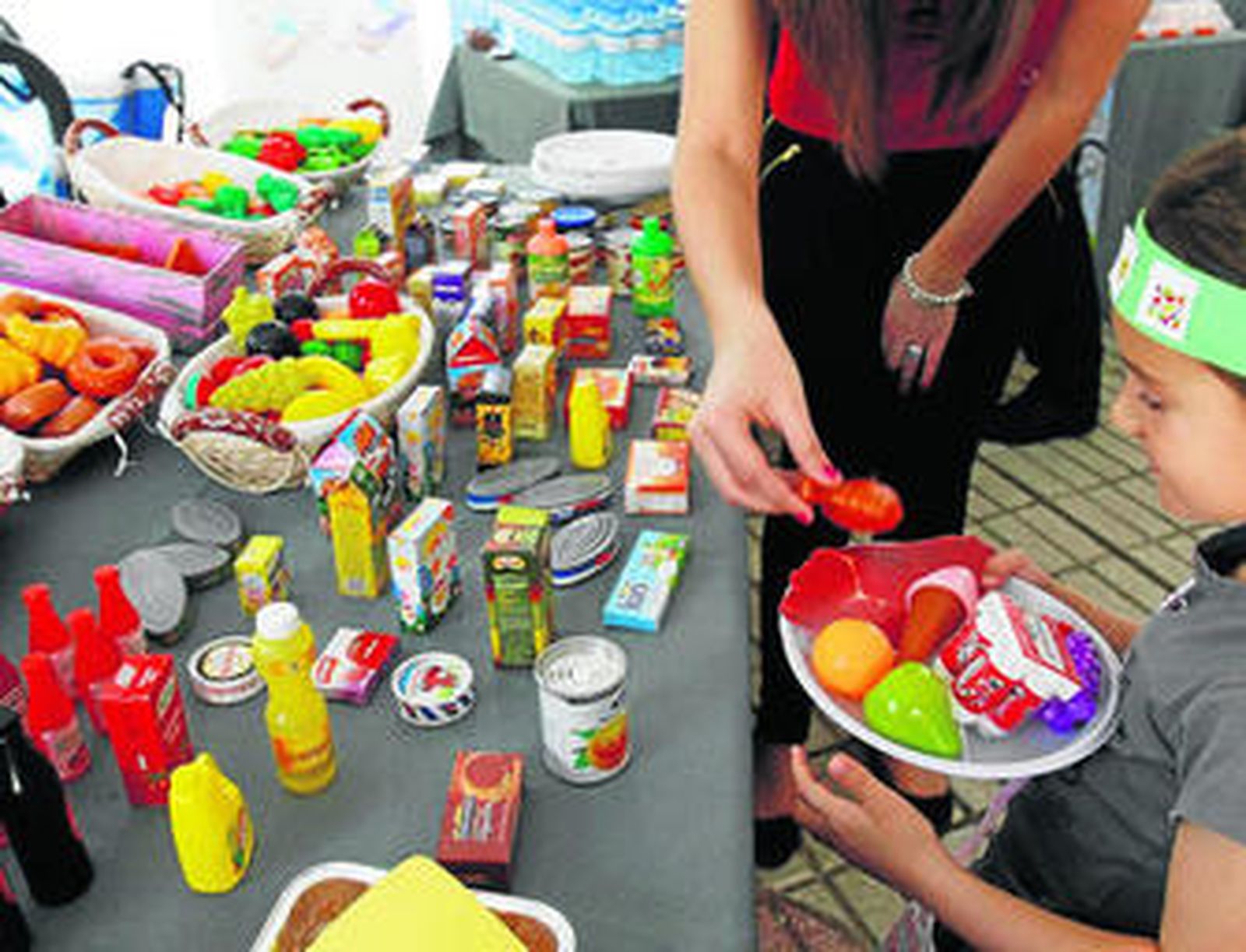 Daniela juega en el 'self-service' de la carpa y coge los alimentos que sabe que puede tomar.