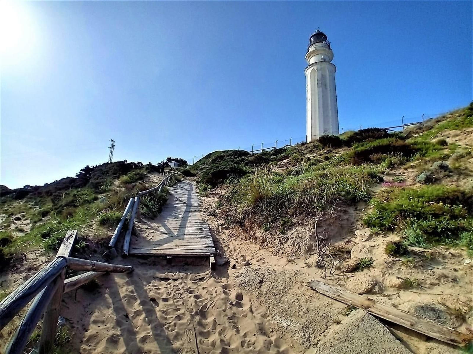 Acceso desde el tómbolo al Faro de Trafalgar, declarado BIC.
