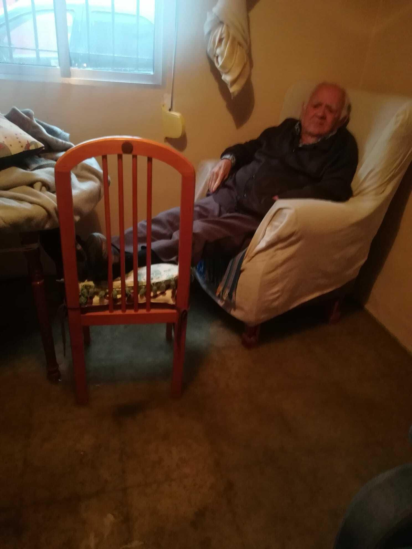 Rafael con las piernas en alto debido a la inundación de su vivienda.